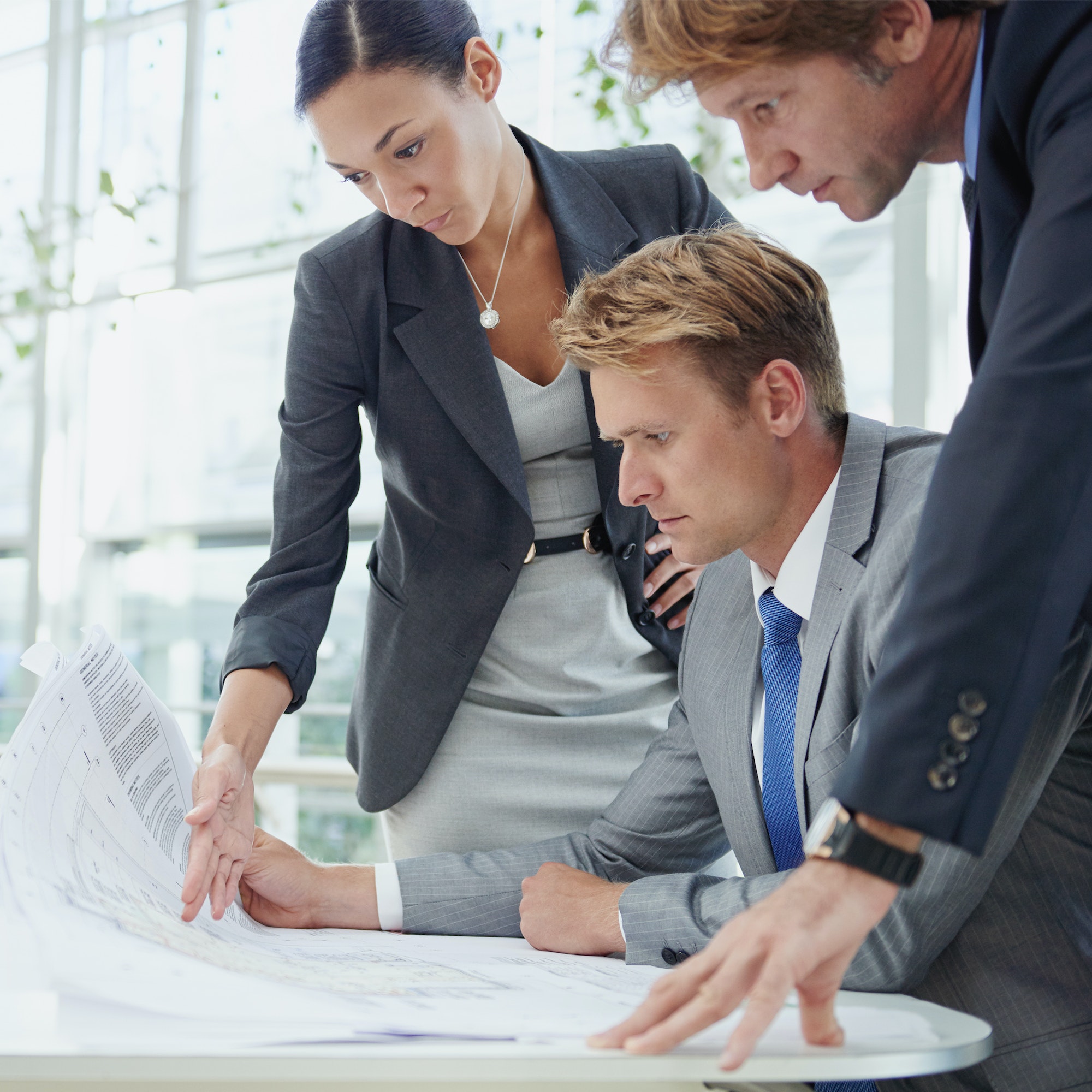 A group of architects reviewing building plans in their office